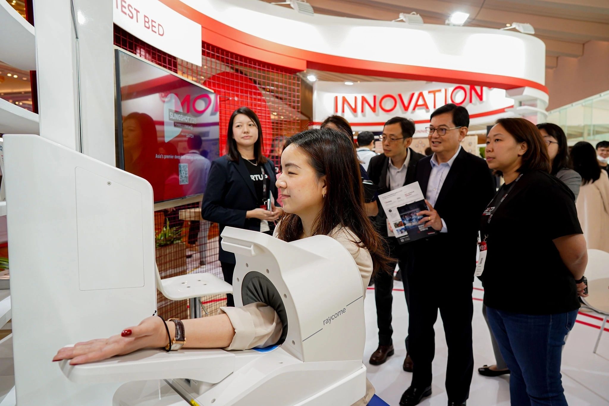VIP delegation touring an innovation showcase booth at a Singapore trade exhibition